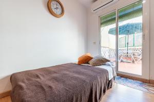 1 dormitorio con 1 cama con reloj en la pared en Bettatur Apartament Ripoll, en Tarragona