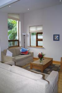 Sala de estar con 2 sofás y mesa de centro en Bright spacious mews in great location, en Booterstown
