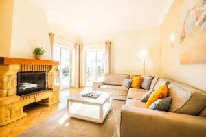 Una sala de estar con un sofá y una chimenea. en Villa Florença by Algarve Vacation, en Albufeira