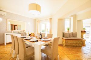 Una cocina y un comedor con mesa y sillas. en Villa Florença by Algarve Vacation, en Albufeira
