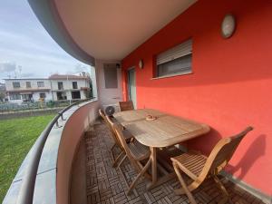 a table and chairs on the balcony of a house at Red House in Monfalcone