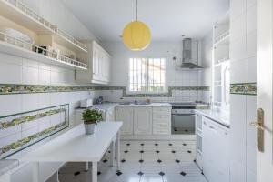 una cocina con armarios blancos y una maceta en AA Guest - Veleta del Jardín de Sierra Nevada, en Alhendín