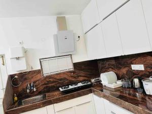 a kitchen with white cabinets and a sink at White House Sky View Theatre Villa in Gachibowli in Hyderabad