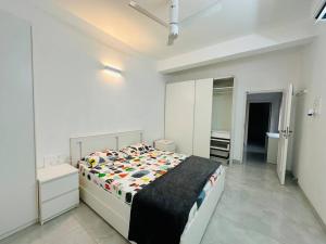 a white bedroom with a bed and a mirror at White House Sky View Theatre Villa in Gachibowli in Hyderabad