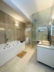 y baño con bañera, ducha y aseo. en White House Sky View Theatre Villa in Gachibowli en Hyderabad