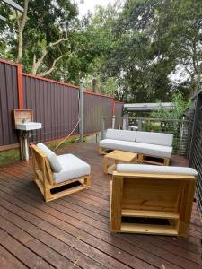een patio met banken en stoelen op een houten terras bij Ideal 3 Bedroom House City Centre Glebe 2 E-Bikes Included in Sydney