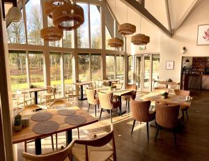 a restaurant with tables and chairs and large windows at Willowbeck Lodge Boutique Hotel in Carlisle