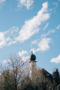 un edificio con una cruz encima en Klostermaier Hotel & Restaurant, en Icking