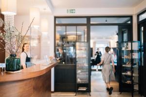 eine Gruppe von Menschen, die an einem Tresen in einem Laden stehen in der Unterkunft Klostermaier Hotel & Restaurant in Icking