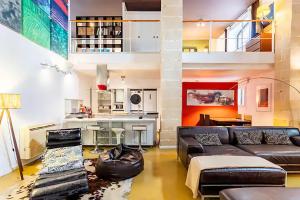 sala de estar con sofá y cocina en artQhost Jerez Huge Loft & Free Parking, en Jerez de la Frontera