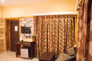 a living room with a couch and a television at HOTEL VARUNA Varanasi in Varanasi