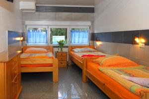 two twin beds in a room with two windows at Ferienwohnung + Monteurwohnungen Krings in Eschweiler