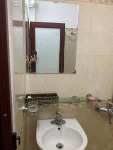 ein Bad mit einem Waschbecken und einem Spiegel in der Unterkunft Nhà Nghỉ Hải Nam in Dien Bien Phu