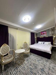 a bedroom with a bed and a table and chairs at Hotel Sherdor in Samarkand