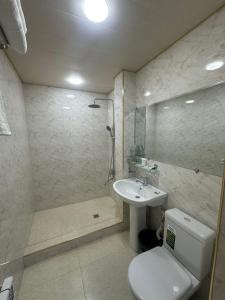 a bathroom with a toilet and a sink and a shower at Hotel Sherdor in Samarkand