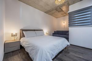1 dormitorio con 1 cama grande y 1 sofá en Brand new home close to all amenities. An exceptionally chic get-away!, en Taʼ Xbiex
