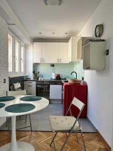 una cucina con armadi bianchi e frigorifero rosso di Gajba Apartment a Belgrado
