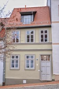 a yellow house with a white door and windows at Pößnecker Werkstätten - Martin Luther in Pößneck