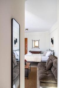 sypialnia z łóżkiem, lustrem i kanapą w obiekcie Rokani Studio II w Kalawricie
