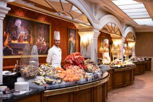 a chef standing behind a buffet of food in a restaurant at Disneyland® Hotel in Chessy