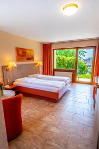 1 dormitorio con cama grande y ventana grande en Wohlfühlhotel Sonnengarten, en Überlingen