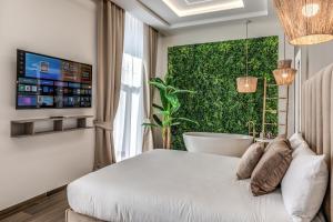 a bedroom with a tub and a green wall at ATAROOMS Suites Napoli in Naples +94 photos