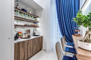 a kitchen with a wooden counter and blue curtains at ATAROOMS Suites Napoli in Naples