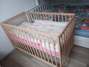 a crib in a room with a bed at Schöne Neubauwohnung in der Natur in Beckingen