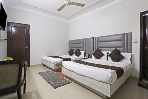 1 dormitorio con 2 camas y techo en Ratandeep International en Nueva Delhi