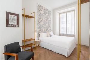 een slaapkamer met een wit bed en een stoel bij Be Mate Málaga Centro in Málaga