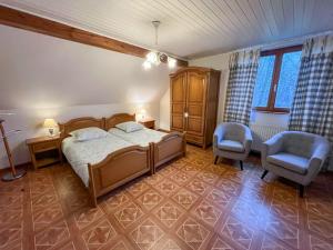 Un dormitorio con una cama y dos sillas. en Le Charme de l'Altenberg, en Neubois