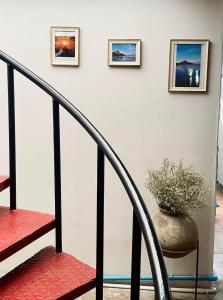 una escalera con tres cuadros en la pared y un jarrón en Wave House Studio Huahin, en Hua Hin