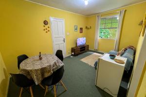 a dining room with a table and a room with yellow walls at Casa na Serra - Cidade Imperial in Petrópolis
