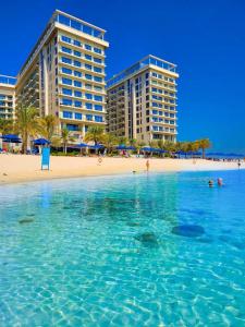 dos edificios altos en una playa junto al océano en Marjan Island Beautiful Apartment Sea View Beach Luxury Rooms Ras Al Khaimah UAE, en Ras al Khaimah