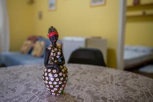 Eine Figur einer Frau, die auf einem Tisch sitzt. in der Unterkunft Casa na Serra - Cidade Imperial in Petrópolis