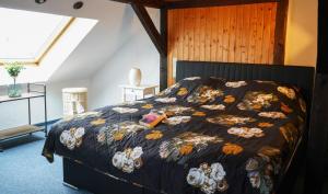 een bed met een zwart dekbed met bloemen erop bij Romantische Wohnung mit Flair in Oldenburg