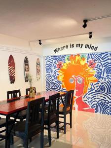 a dining room with a table and a mural at Wave House Studio Huahin in Hua Hin