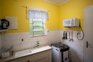 uma pequena cozinha com um lavatório e um micro-ondas em Casa na Serra - Cidade Imperial em Petrópolis