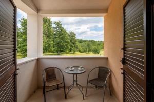 einen Balkon mit einem Tisch, 2 Stühlen und einem Fenster in der Unterkunft Villa Genia II in Poreč