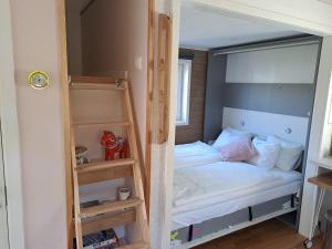 a small bedroom with a bunk bed and a mirror at Lillhuset nära Stockholm in Tungelsta