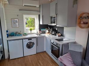 a kitchen with a washing machine and a washer at Lillhuset nära Stockholm in Tungelsta