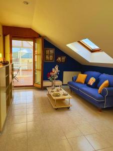 sala de estar con sofá azul y mesa en Apartamentos Melgarden - El Balcón de los Lirios, en Argoños