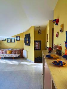 cocina con paredes amarillas y sala de estar con sofá en Apartamentos Melgarden - El Balcón de los Lirios, en Argoños