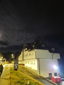 a white building on the side of a street at night at Sobe sa kupatilom Jajce in Jajce