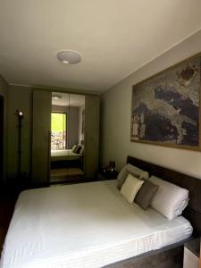 um quarto com uma grande cama branca e um espelho em Sém chì, relaxing cottage in the mountains em Gromo