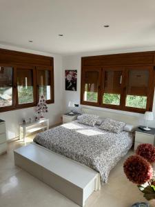 1 dormitorio con 1 cama grande y algunas ventanas en Villa Rouse, en Sant Feliu de Guíxols