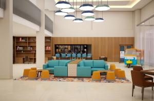 uma biblioteca com cadeiras azuis e uma mesa em Zone by The Park Digha em Digha