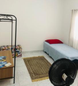 een slaapkamer met een bed, een tafel en een ventilator bij Casa-Sobrado próximo à Balsa de Ilha Bela e Rodoviária in São Sebastião