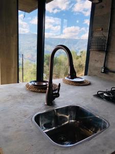 a kitchen counter with a sink and a window at Cabana Efatah - Pousada Colina dos Ventos in Urubici