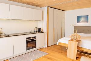 a white bedroom with a bed and a fireplace at Luxus-Apartements direkt am Attersee in Seewalchen